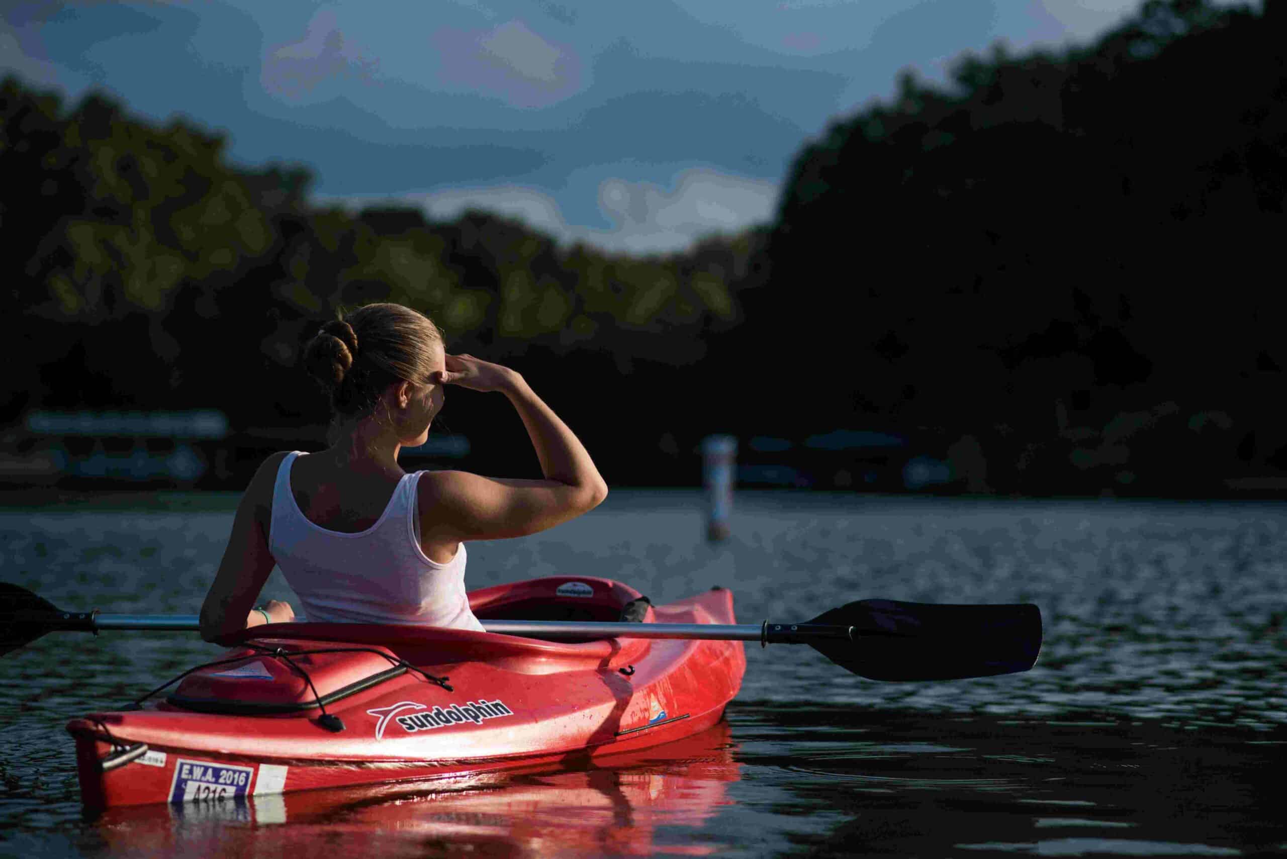 Sportbegeisterte Frau fährt Kajak auf einen See